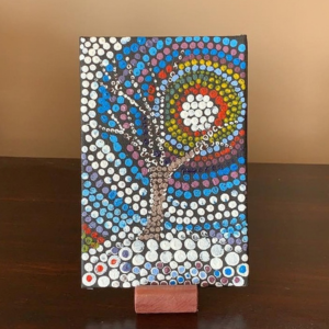 Dot painting mandala in red, turquoise and yellow on a black canvas, by Maureen Kerr' and 'Dot painting of a tree under a rainbow sun, by Maureen Kerr